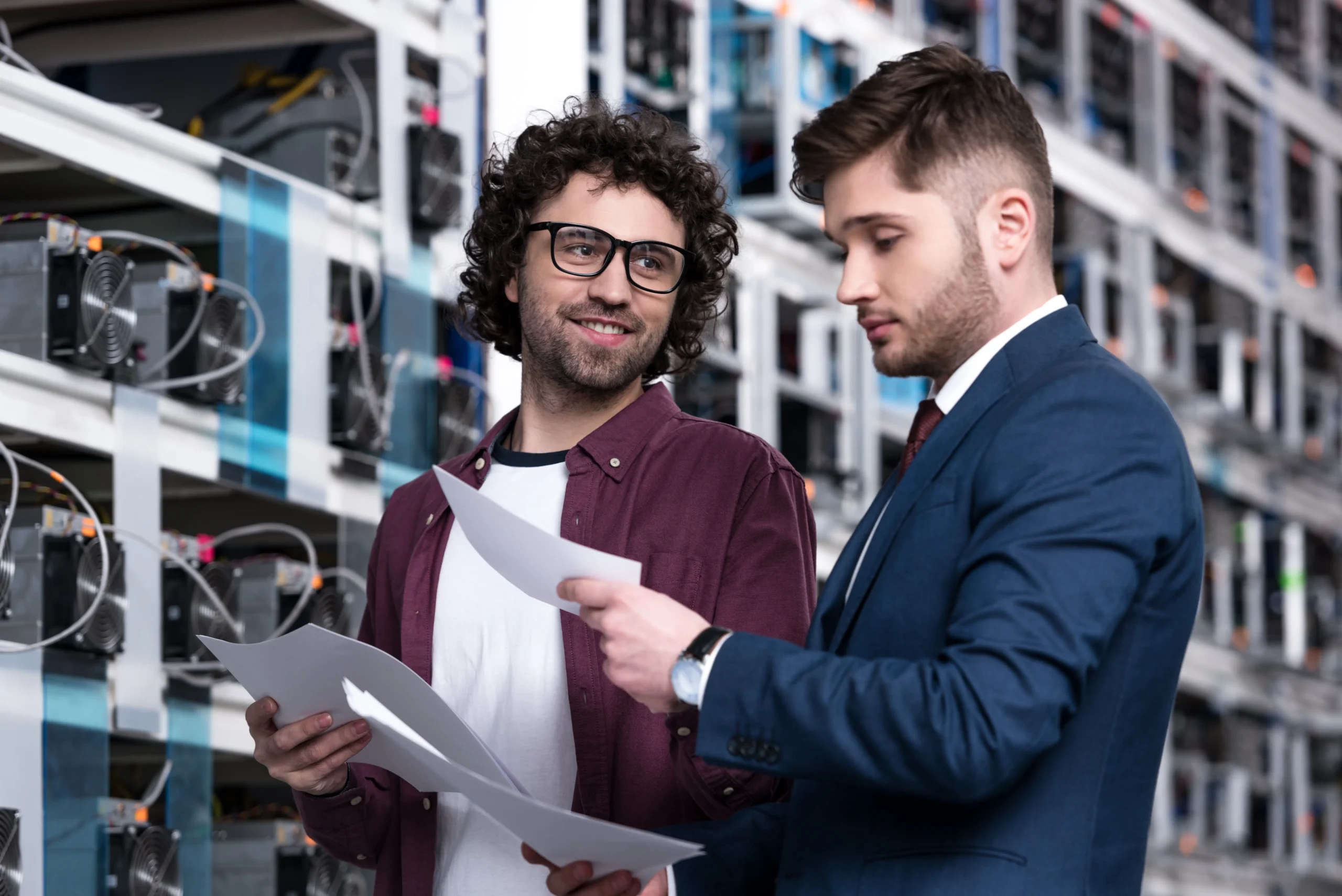 Two technology experts discussing detailed project plans in a server room, embodying Nimbl's expert-driven approach to ensuring a successful and effective implementation of fiber solutions